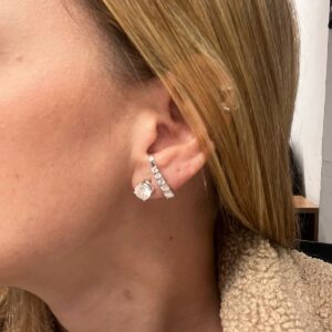 Orelha feminina com brinco de ouro branco e pedra de moissanita.