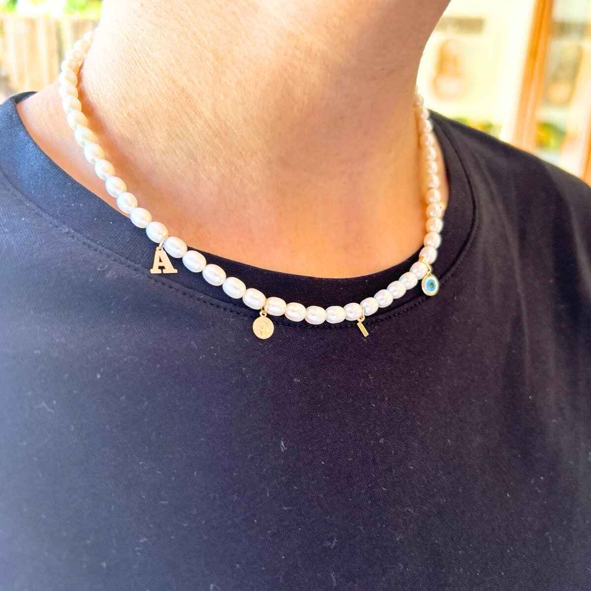 Pescoço feminino com colar de pérolas.